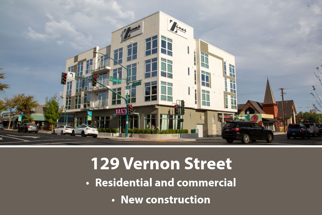 A multi-story residential building with retail shops on the ground floor. 